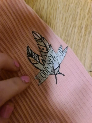 Rosa ribbad topp Odd Molly - Supersöt ljusrosa ribbad topp från Odd Molly med en röd roset där fram och vit spets runt nacken. Sitter som en S men funkar säkert som M. Fråga gärna om ni har frågor💕