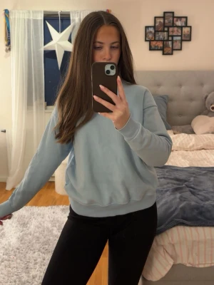 Ljusblå sweatshirt- Pull&Bear  - Ljusblå sweatshirt från Pull&Bear i storlek Xs. Tröjan har ett litet tryck på ärmen längst ner(se bild). 