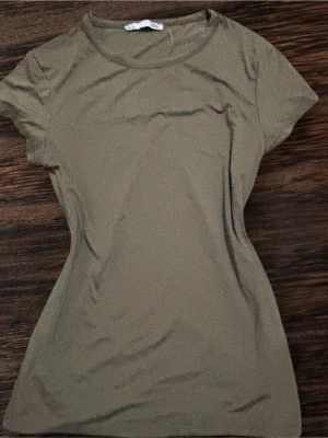 Olivgrön t-shirt från 157 - Vi kan diskutera priset. En enkel olivgrön t-shirt från 157 med rund halsringning och korta ärmar. Tillverkad i mjuk bomull som känns skön mot huden. Perfekt basplagg att matcha med jeans eller shorts.