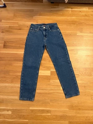 Blå straight jeans från Tommy Hilfiger  - Säljer ett par klassiska blå straight jeans från Tommy Hilfiger. Storlek 164. Sparsamt använda, därav super skick! 