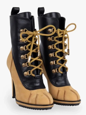 Moschino x H&M höga stövletter - Unika stövletter med hög klack från Moschino x H&M. Skorna har skinn upptill och mocka nedtill, med guldfärgade snörhål och gula snören. Tåpartiet är markerat och sulan har grovt mönster. Perfekta för dig som vill sticka ut.