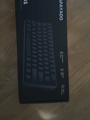 APAYADO K61 Mekaniskt Tangentbord - Kompakt mekaniskt tangentbord med blå brytare, RGB-belysning och USB-C anslutning. Tangenterna är i gott skick med minimalt slitage. Perfekt för gaming och arbete. Levereras i originalkartong. Inga synliga defekter.