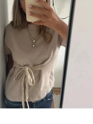 Beige stickad topp med knytband Zara - Lägger upp igen så det blir fri frakt!!! Inga defekter, inte nopprig super skick! Står ej storlek då min vän klippte bort lappen för det kliade, men tror det är S då jag bör xs-S och den passar. Men passar mellan xs-m då man kan välja hur tajt man vill knyta den