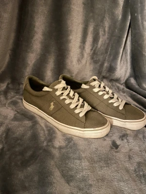 Olivgröna sneakers från Polo Ralph Lauren - Säljer ett par olivgröna Polo Ralph Lauren skor i storlek 41, de är använda 2-4 gånger och har inget slitage, skick 9.5/10, kan gå ner lite i pris vid en snabb affär!