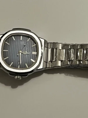 Ny klocka  - Bilderna visar en klocka med tillbehör, ingen väst finns att beskriva.