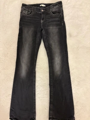 Svarta bootcut jeans med slitningar - Snygga svarta jeans med bootcut passform. Ljus tvätt både fram och bak och storlek 158 passar även mig som är 160 lång. 