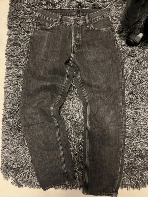 Grå Barrel jeans från Weekday 27/30 - Säljer ett par grå Barrel jeans från Weekday i storlek 27/30. De har en loose passform med raka ben och klassisk femficksdesign. Jeansen är tillverkade i denim med tydliga sömmar och har en cool, lite tvättad look.