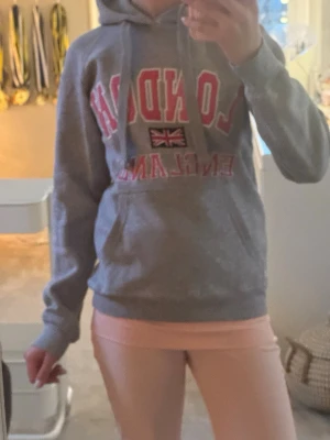 London hoddie  - En mjuk och skön grå med rosa detaljer London Hoodie. Endast andvänd ett par fåtal gånger. 