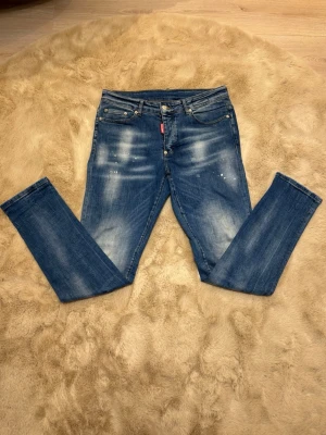 Disquared 2 jeans - Säljer ett par blå Disquared 2 jeans med skinny passform och snygga slitningar samt ljusa partier framtill. Jeansen har klassisk femficksmodell, normal midja och är tillverkade i mjukt jeansmaterial. Perfekta för dig som gillar en smal siluett och coola detaljer. Kom dm för eventuella frågor 🧐pris kan diskuteras 😇💯