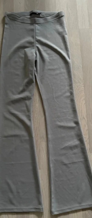Grå bootcut byxor oanvända  - Säljer ett par gråa bootcut byxor från 157 i storlek M. Byxorna har en mjuk och stretchig känsla, med hög midja och utsvängda ben. Perfekta för dig som gillar en enkel men trendig look. Oanvända pga fel storlek. 