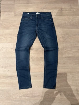 Only & Sons jeans - Snygga blå jeans från Only & Sons i modellen Loom Slim. Klassisk femficksdesign, normal midja och smal passform. Tillverkade i mjukt jeansmaterial med diskreta sömmar och metallknapp framtill. Perfekta till vardagslooken.