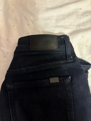 Mörkblå skinny jeans Calvin Klein - Säljer ett par mörkblå skinny jeans från Calvin Klein Jeans. Klassisk femficksmodell med diskreta CK-detaljer på ficka och knapp. Jeansen har en smal passform och är tillverkade i stretchigt denim för extra komfort.