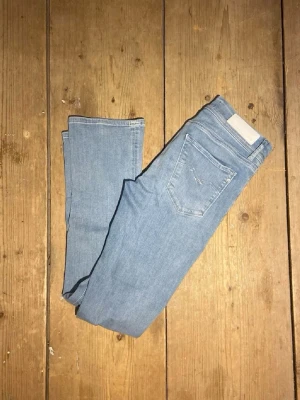 Replay ljusblå jeans W28 L32 - Säljer ett par ljusblå jeans från Replay i klassisk bootcut-modell. Jeansen har fem fickor, normal passform och är tillverkade i mjukt denimtyg. Perfekta för dig som gillar en avslappnad men ändå snygg look.