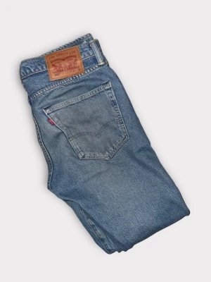 Levi's 512 blå jeans straight fit - Säljer ett par klassiska Levi's 512 jeans i ljusblå tvätt. Modellen har rak passform, fem fickor och hög midja. Jeansen är tillverkade i slitstarkt bomullsdenim och har den ikoniska Levi's-lappen bak samt röd Levi's-tag på bakfickan.