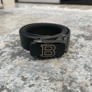 Läderbälte med automatiskt spänne – justerbar längd  - 📏 Storlekar: 130 cm & 135 cm Kan enkelt klippas i änden för perfekt passform.  🧵 Design: • Texturerat läder för en klassisk look • Slät läderfinish för en stilren, minimalistisk känsla (Bilder kan skickas vid intresse)  🔒 Automatiskt spänne: Smidigt klicksystem på insidan som sitter stadigt och enkelt justeras. Ger ett elegant och minimalistiskt uttryck.  🎨 Välj din logga: Flera loggor finns – välj din favorit. kolla min profil för alla alternativ 😊  📦 Snabb leverans 💬 Frågor? Hör av dig!