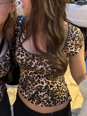 Leopardmönstrad croppad topp - Säljer en snygg croppad topp med leopardmönster. Toppen har korta ärmar och en rundad urringning. Endast använd ett fåtal gånger.