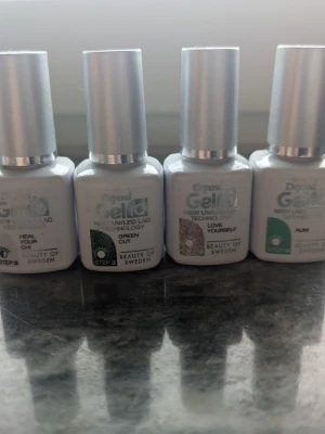Depend GeliQ nagellack 4-pack - Fyra Depend GeliQ UV/LED nagellack i olika färger: ljusrosa glitter, mörkgrönt, roséguld glitter och klargrönt. Flaskorna är vita med silverlock och varje lack har en unik nyans som syns på provlapparna. Perfekt för dig som gillar att fixa naglarna hemma. Endast swatchade 