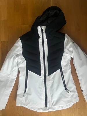 Skidjacka Everest - Säljer en svart-vit skidjacka från Everest i storlek 40. Snygg och funktionell skid- och snowboardjacka från Everest, perfekt för kalla dagar i backen. Lätt vadderad för bra värme utan att kännas klumpig – bekväm att bära hela dagen.   Fickor: ✔ 2 bröstfickor ✔ 2 sidofickor (vattentäta dragkedjor) ✔ Liftkortsficka på ärmen ✔ 2 innerfickor (mesh + dragkedja) Nypris: 1799 Säljes för: 800kr