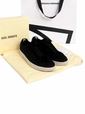 Svarta sneakers från Axel Arigato - Snygga svarta sneakers från Axel Arigato i mocka med vit platt sula. Minimalistisk design utan synliga snören och diskreta detaljer. Perfekta för dig som gillar stilrena och moderna skor.