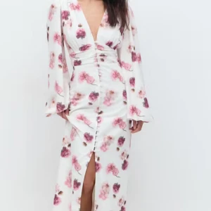 Vit blommig långklänning - Säljer denna virala klänning från gina tricot i storlek 34, aldrig använd bara testad, lappen kvar. Första knappen högst upp har lostnat vid frakt, så har fixat det på ett sätt(se bild 3) klänningen är normal i storlek, tyvärr för liten för mig som är en 36a. Säljes för 800 då jag köpte den dyrt i andrahand. 