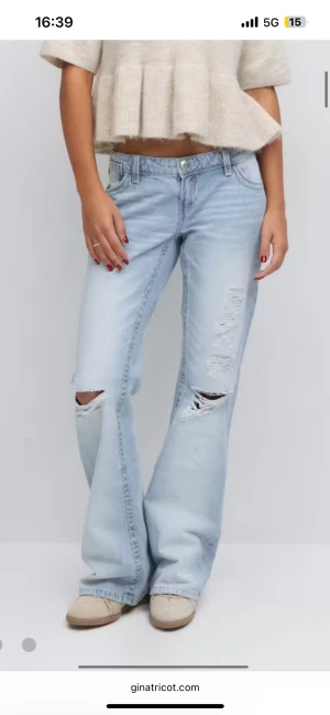 Ljusblå ripped wide jeans från Gina Tricot - Säljer ett par ljusblå jeans från Gina Tricot med slitna detaljer och hål på knäna.  Typ oanvända och säljer för att de är lite för stora och lite för korta! 