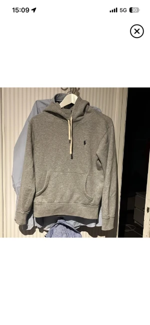 Grå hoodie från Polo Ralph Lauren XS - Snygg grå hoodie från Polo Ralph Lauren i storlek XS. Klassisk design med huva och snörning, samt en stor magficka framtill. Mjuk bomullskvalitet och diskret logga på bröstet. Perfekt för chill dagar eller när du vill ha en clean look.