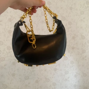 Liknande handväska  - Säljer en svart handväska, behöver pengarna därför vill jag få den såld snabbt och billig! Köpt på gatumarknad i Spanien!