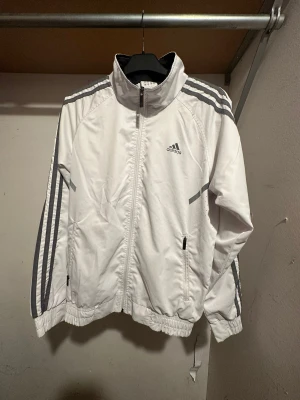 Vit Adidas vindjacka - Vit vindjacka från Adidas, fin och i väldigt bra skick!