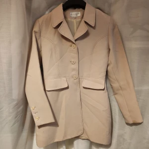 Beige kavaj från Hennes Collection - Stilren beige kavaj från Hennes Collection med klassisk krage, tre knappar framtill. Snygg passform och helfodrad insida.