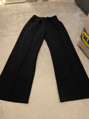 Svarta kostymbyxor  - Snygga svarta kostymbyxor. Resårband längst upp. Ytterbenslängd 104, innerbenslängd 76, midjemått 32. Inga skador. 💕