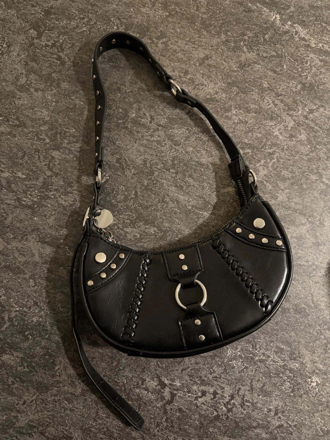 Svart axelväska med nitar och ringdetalj