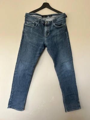 Blå jeans från Massimo Dutti - Snygga blå jeans från Massimo Dutti med klassisk femficksdesign och knappstängning. 