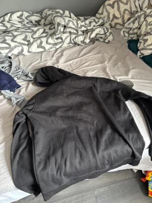 Svart hoodiejacka från Polo Ralph Lauren - Svart hoodiejacka med dragkedja från Polo Ralph Lauren. Jackan har huva, två stora fickor framtill och en broderad vit logga på bröstet. Tillverkad i mjuk bomull och har långa ärmar. Perfekt för en chill och avslappnad stil.