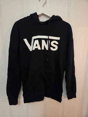 Svart hoodie från Vans med logga - Säljer en svart hoodie från Vans med stor vit logga på bröstet i stl S. Den är använd men i väldigt bra skick! Nypris ca 700-800 säljes för 200