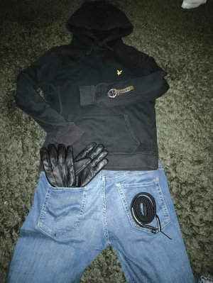 Svart hoodie från Lyle & Scott - Svart hoodie från Lyle & Scott. Hoodien är riktigt fräsch och kan lätt kombineras med annat för en schysst outfit. Varan är använd ett fåtal gånger och har inga synliga defekter!