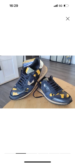Valentino Rockrunner sneakers  - Säljer ett par Valentino Rockrunner sneakers med blå, beige och gul camouflage-mönster. Storlek 43. Endast skorna följer med