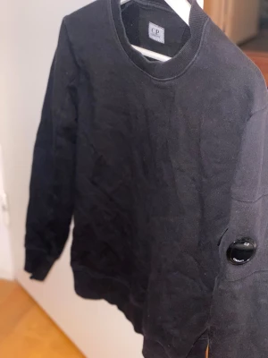 Svart sweatshirt från C.P. Company - Klassisk Svart sweatshirt från C.P. Company med rund hals och ribbade muddar. Storlek S