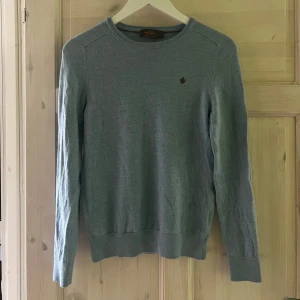 Ljusblå merinoullströja från Morris - Säljer en ljusblå stickad tröja från Morris i 100% merinoull. Tröjan har rund halsringning, långa ärmar och en liten broderad logotyp på bröstet. Perfekt för lager-på-lager och stilren look. Sitter mer som en mindre m än en ”vanlig” m! Kan tänka mig att göra ett byta mot något likande.