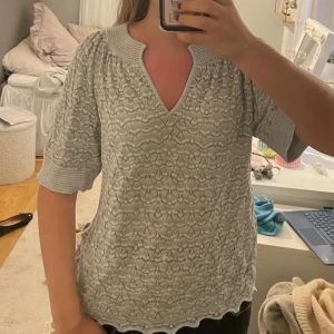 Ljusblå mönstrad tröja - Säljer denna fina mönstrade toppen med v ringning. Den sitter som M men passar även S/L. Endast använd en gång.