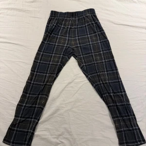 Rutig byxa från Only & Sons M - Svarta och gråa mysbyxor från Only & Sons med rutigt mönster och elastisk midja. Sköna och avslappnade med rak passform, perfekta för en chill dag. Tillverkade i mjukt material som känns bekvämt hela dagen.