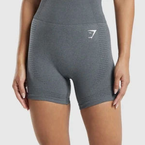 Grå seamless shorts från Gymshark - Säljer ett par grå seamless shorts från Gymshark med hög midja och diskret hålmönster längs sidorna. Stretchigt material som sitter tight och är perfekta för träning. Gymshark-logga i vitt framtill. Supersnygga och bekväma för gymmet eller löprundan. Nypris ca 500kr