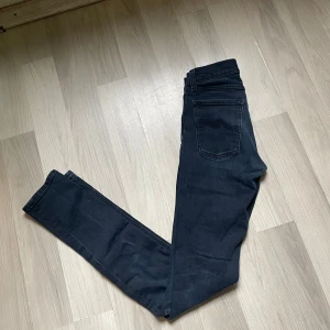 Mörkblå skinny jeans från Nudie Jeans - Snygga mörkblå skinny jeans från Nudie Jeans med slitningar på benen.                                Jeansen har smal passform.                                                                          W27 L34                                                                  Skriv vid frågor 