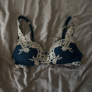 Intimissimi bh - Säljer en bh med vackra ljusa spetsdetaljer och broderade blommor från intimissimi. Bh:n har justerbara axelband och hakknäppning bak. Perfekt för dig som gillar romantiska detaljer och snygg design. Färgen är blå/grön och säljs inte längre. Den är i mycket fint skick och har används några fåtal gånger då den är för stor för mig. Storlek 75C. Lappen i den är tyvärr bortklippt.🫶🏻