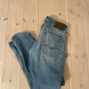 Replay rocco straight fit - Säljer ett par ljusblå jeans från Replay med klassisk femficksdesign och raka ben. Jeansen har snygga slitningar och Replay-logga på bakfickan samt läderpatch i midjan. Storlek:W31 L34. Hör av dig vid funderingar!