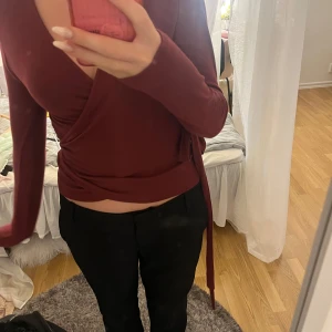 Vinröd omlottopp från 157, stl S - Säljer en vinröd omlottopp från 157 i storlek S. Toppen har långa ärmar, djup v-ringning och knytband i midjan som ger en snygg passform. Mjuk och stretchig känsla, perfekt till svarta byxor eller jeans. Enbart änvänd en gång så är som ny🩷