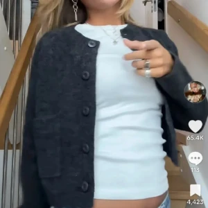 Stickad kofta - Säljer en mörkgrå kofta med stora knappar framtill och fickor. Koftan har en klassisk rak passform och är långärmad. Perfekt att slänga över en t-shirt för en chill look. Skriv för egna bilder💕💕 använd en gång