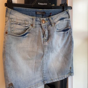 Ljusblå jeanskjol från ONLY - Snygg ljusblå low waist jeanskjol från ONLY , slitna detaljer och kontrastsömmar. Kjolen har knapp och dragkedja. Säljer för inte passar mig i midjan  