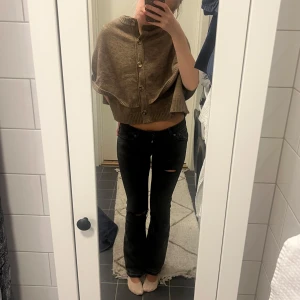 Lågmidjade jeans - Ett par svarta lågmidjade jeans med snygga slitningar. 