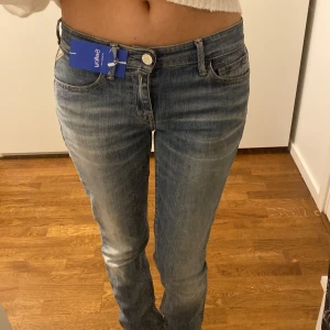 Replay Blue Jeans - Snygga Replay Blue Jeans i klassisk blå tvätt. Modellen har en modern låg midja och lite mer straight bootcut. Jeansen har fem fickor och unika Replay-detaljer på bakfickan och insidan av linningen. Midjemått: 37cm, innerbenslängd: 86cm.