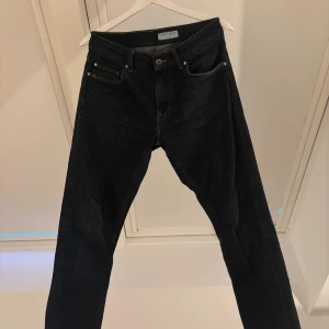 Tiger of Sweden mörkblå jeans Pistolero - Mörkblå jeans från Tiger of Sweden i modellen Pistolero. Klassisk femficksdesign med raka ben och snygga kontrastsömmar. Jeansen är tillverkade i bomull och har en stilren look som passar perfekt till sneakers eller boots.